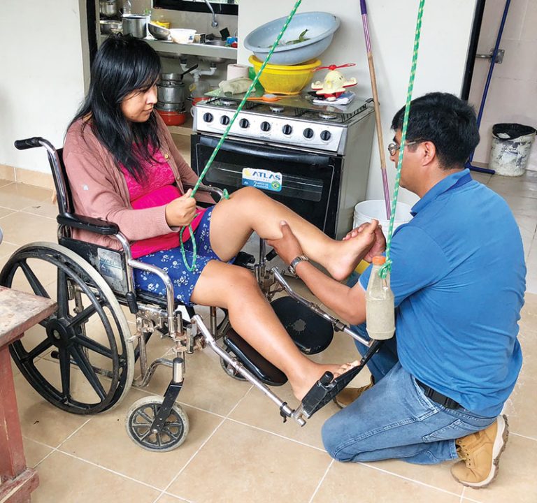 During a home visit in Entre Ríos, Willy García, a nurse with the Social Justice Foundation, teaches muscle strengthening exercises to Yeydy Olivera. 