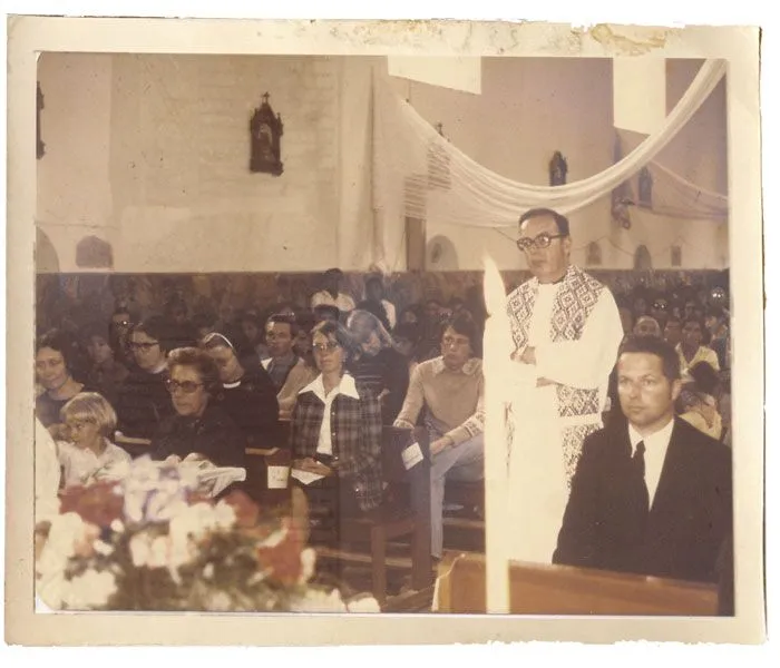 Maryknoll Father Edward Moore walks in procession during the funeral Mass for the plane crash victims. Father Woods’ brother is seated at right. 