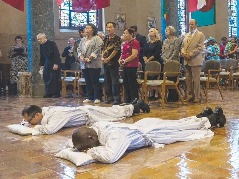 Ordinands Matthew Sim and Patrick Okok lie prostrate for the Litany of Supplication. The Mass was held at Our Lady Queen of Apostles Chapel. 
