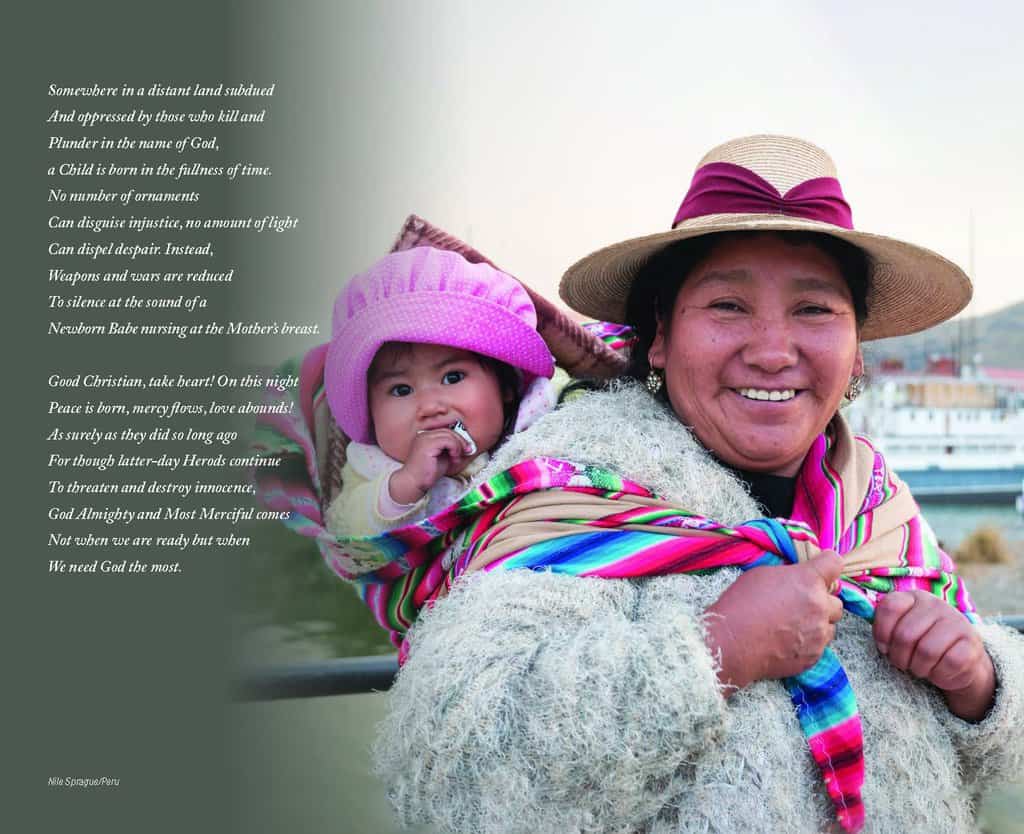 A smiling mother dressed in colorful, warm clothes carries her baby, adorned in a large pink hat, on her back.