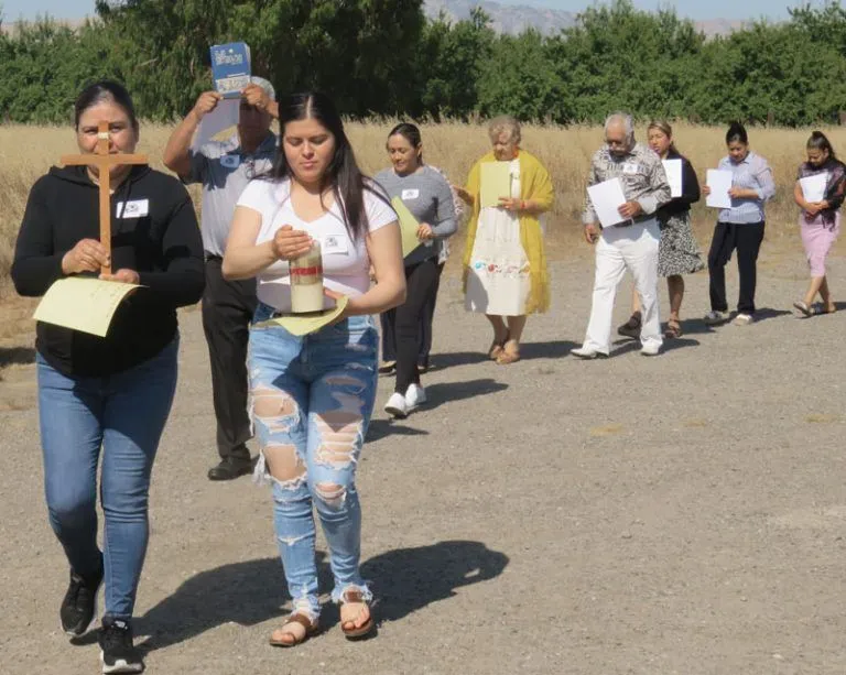 Erika Juárez and her daughter Angélica Magaña, of the Harney Lane Migrant Center, lead a procession during a workshop for farmworker pastoral teams.