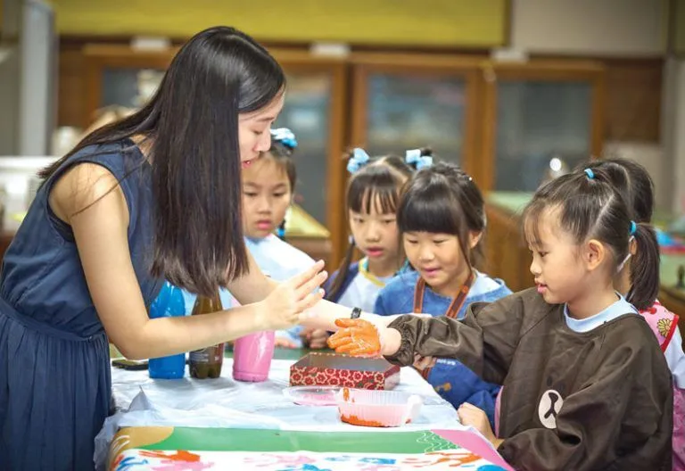 First grade students paint banners to celebrate their first 100 days of school. This initiative combines academic lessons with dynamic activities that foster socialization.