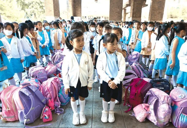At the start of each school day, primary section students line up for morning assembly to listen to announcements.