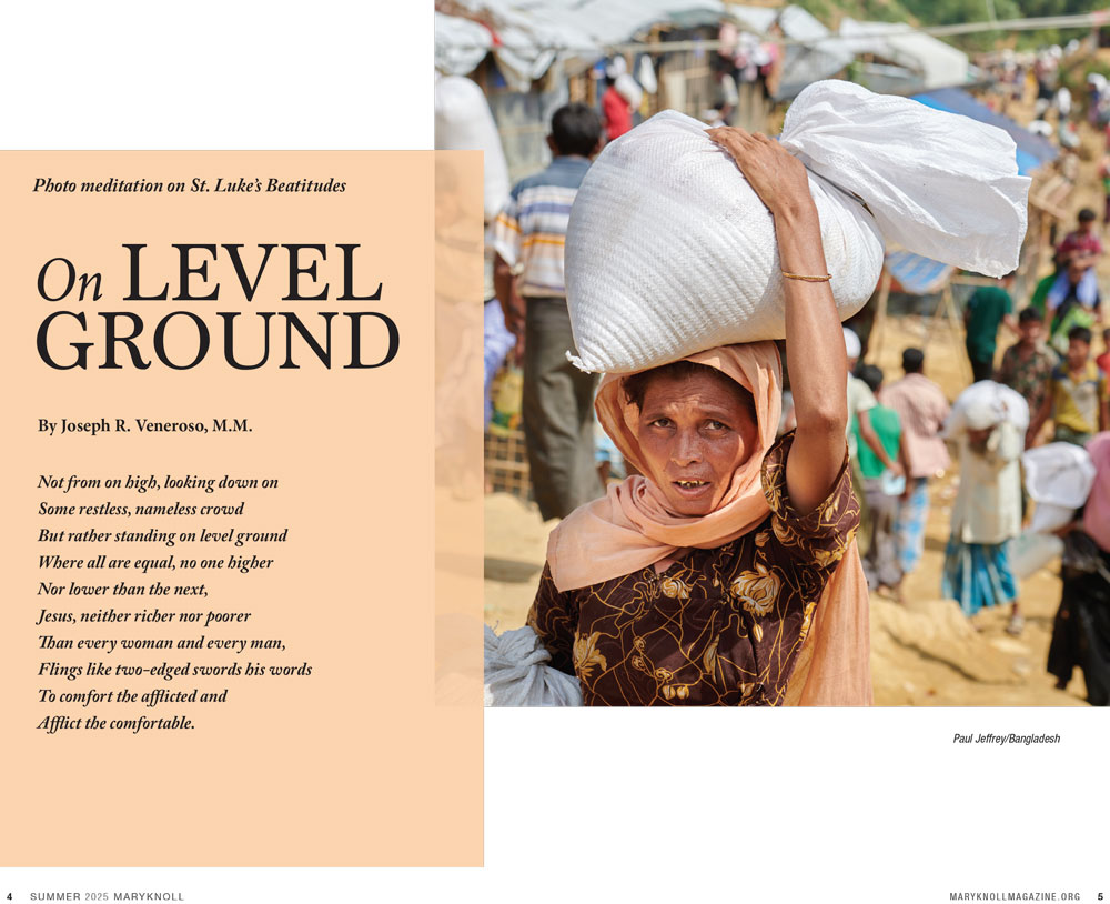 A woman in a headscarf is carrying a large bundle on her head