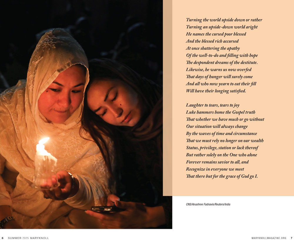 Two women with a candle praying with one woman's head resting on the other woman's shoulder