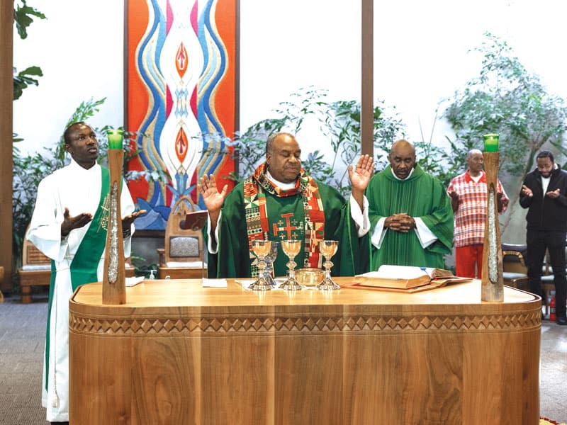 El diácono transitorio Patrck Okok asiste al Padre David Jones, durante una Misa dominical el pasado octubre en la Parroquia St. Benedict the African en el vecindario de Englewood, Chicago. (Octavio Durán, OFM/EE.UU.)