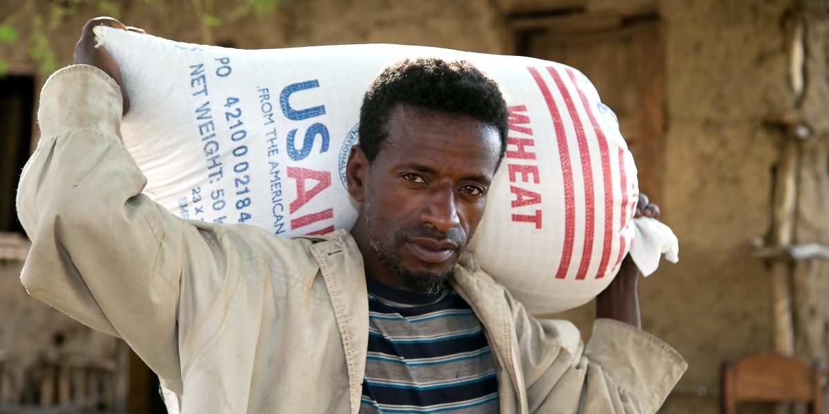 A man is pictured in a file photo carrying a bag of wheat supplied by Catholic Relief Services and USAID for emergency food assistance in a village near Shashemane, Ethiopia. (OSV News/Nancy McNally, Catholic Relief Services)