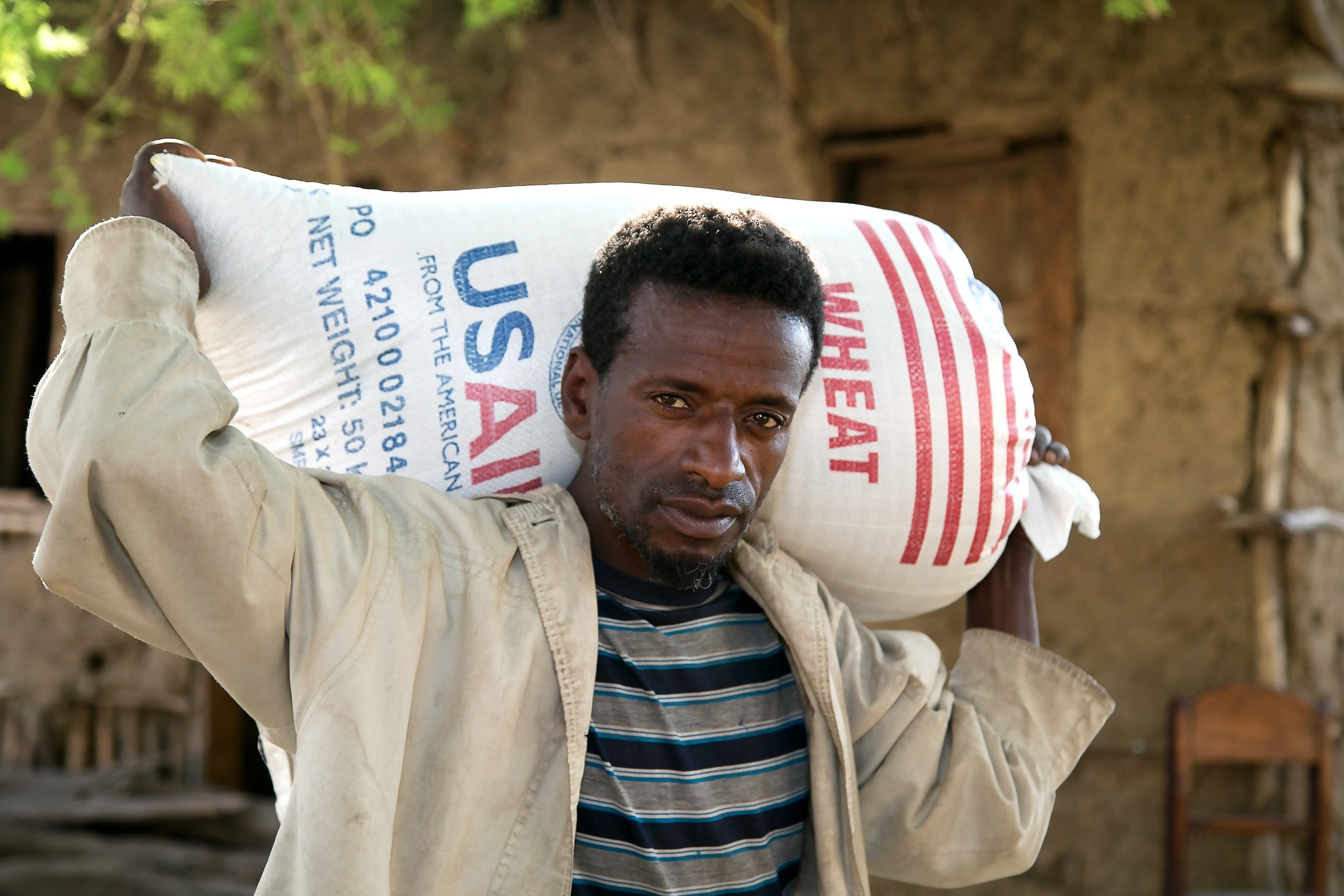 A man is pictured in a file photo carrying a bag of wheat supplied by Catholic Relief Services and USAID for emergency food assistance in a village near Shashemane, Ethiopia. (OSV News/Nancy McNally, Catholic Relief Services)