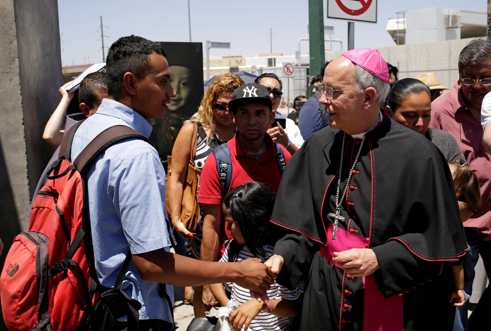 Bishop Mark J. Seitz of El Paso, Texas, greets a Salvadoran migrant in Ciudad Juarez, Mexico, June 27, 2019, who was deported from the U.S. after crossing the Paso del Norte international border from El Paso. (OSV News/Jose Luis Gonzalez, Reuters)