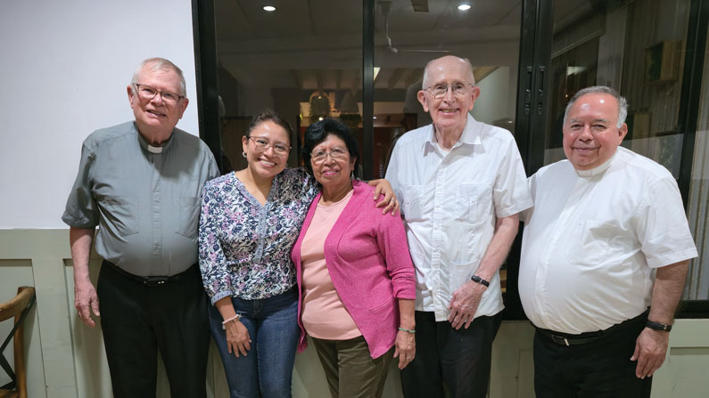 Sofía Cruz and Clelia Estrada gather with Maryknoll Fathers John Northrop (far left) and John Spain and with pastor of Cristo Salvador parish, Father Joaquín Álvarez (far right), in the Zacamil neighborhood of Mejicanos, in metropolitan San Salvador.