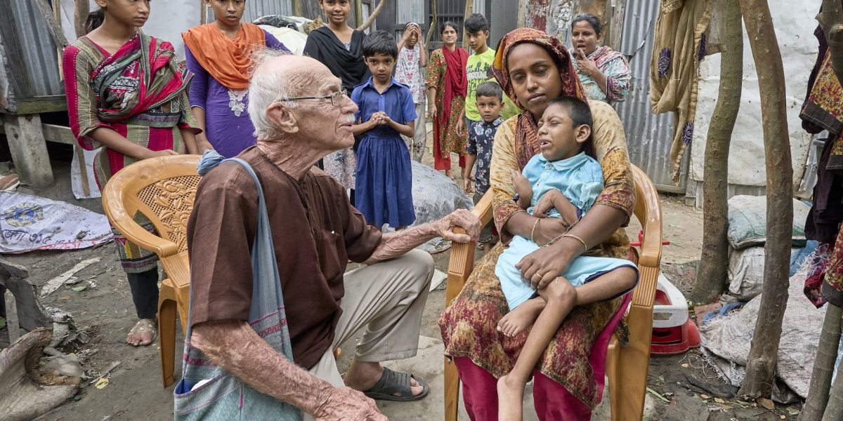 Maryknoll Father Robert McCahill visits 8-year-old Jair and his grandmother, Rohima, in the village of Batabhog near Srinagar. Father McCahill has spent five decades in Bangladesh helping poor families access medical care for children with disabilities. (Paul Jeffrey/Bangladesh)