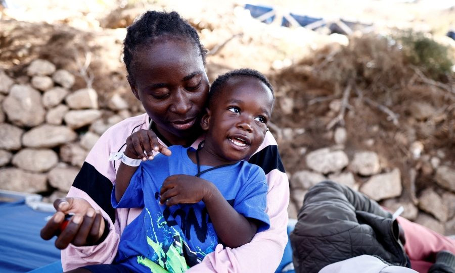 A woman from Cameroon sits with her son outside a reception center for irregular migrants after arriving on the Italian island of Lampedusa Sept. 15, 2023. (OSV News/Yara Nardi, Reuters)