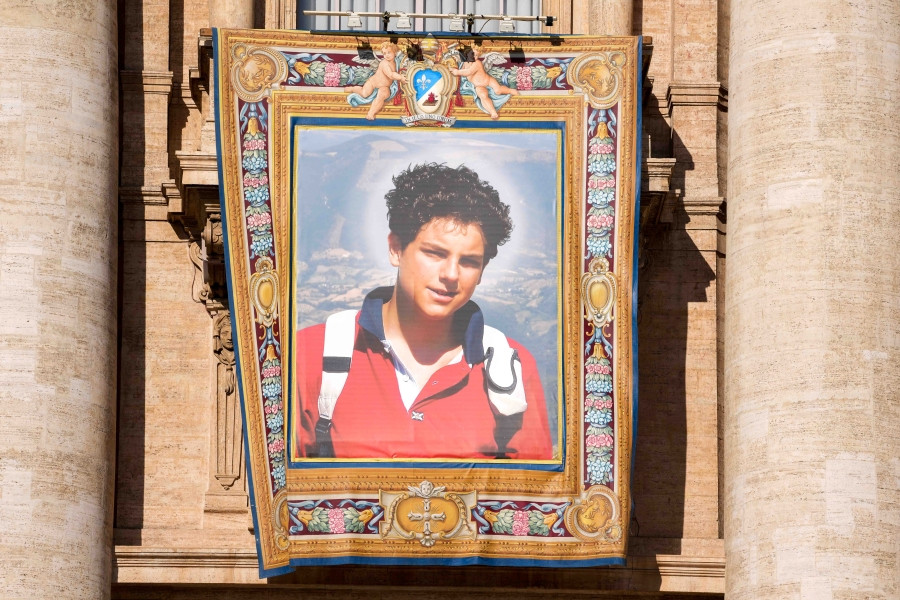 A tapestry depicting St. Carlo Acutis hangs from the facade of St. Peter’s Basilica during the Mass for his canonization at the Vatican Sept. 7, 2025. (CNS/Lola Gomez)