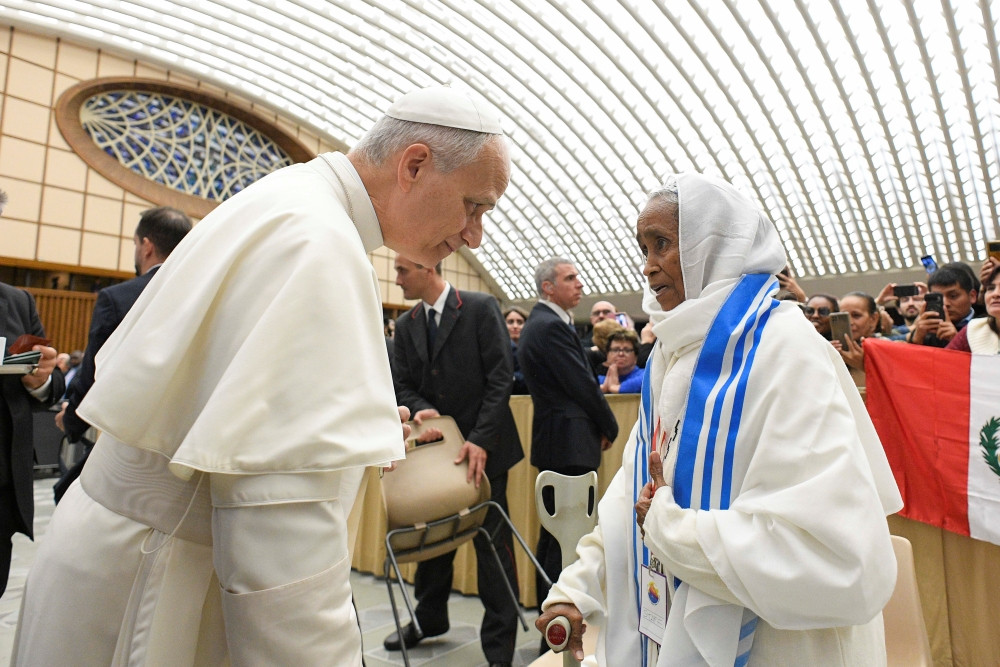 Pope Leo XIV greets a woman during a gathering of popular movements as part of their Jubilee in the Paul VI Audience Hall at the Vatican Oct. 23, 2025. (CNS/Vatican Media)