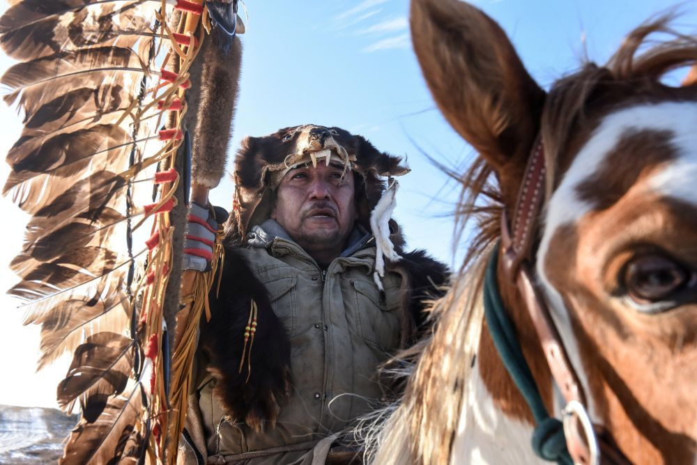 A Lakota person rides a horse with a sacred staff during a horse ride to meet Brad Upton, descendant of the commander of the Wounded Knee massacre on the Cheyenne River reservation in Eagle Butte, S.D., Nov. 6, 2019. Bishop Scott E. Bullock of Rapid City, S.D., and the state’s Jesuits, have condemned Defense Secretary Pete Hegseth’s decision to retain the Medal of Honor for the U.S. soldiers that massacred 300 Lakota people at Wounded Knee in 1890. (OSV News/Stephanie Keith, Reuters)