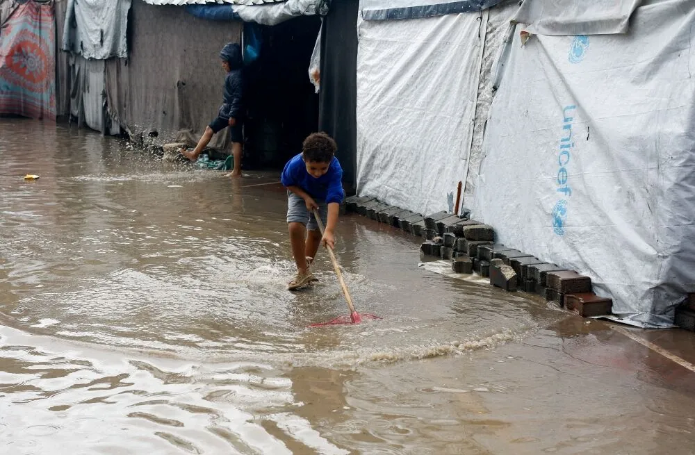 Displaced Palestinian children stand in flood water as they shelter at a flooded tent camp during a rainy day in Gaza City Nov. 25, 2025. (OSV News/Mahmoud Issa, Reuters)