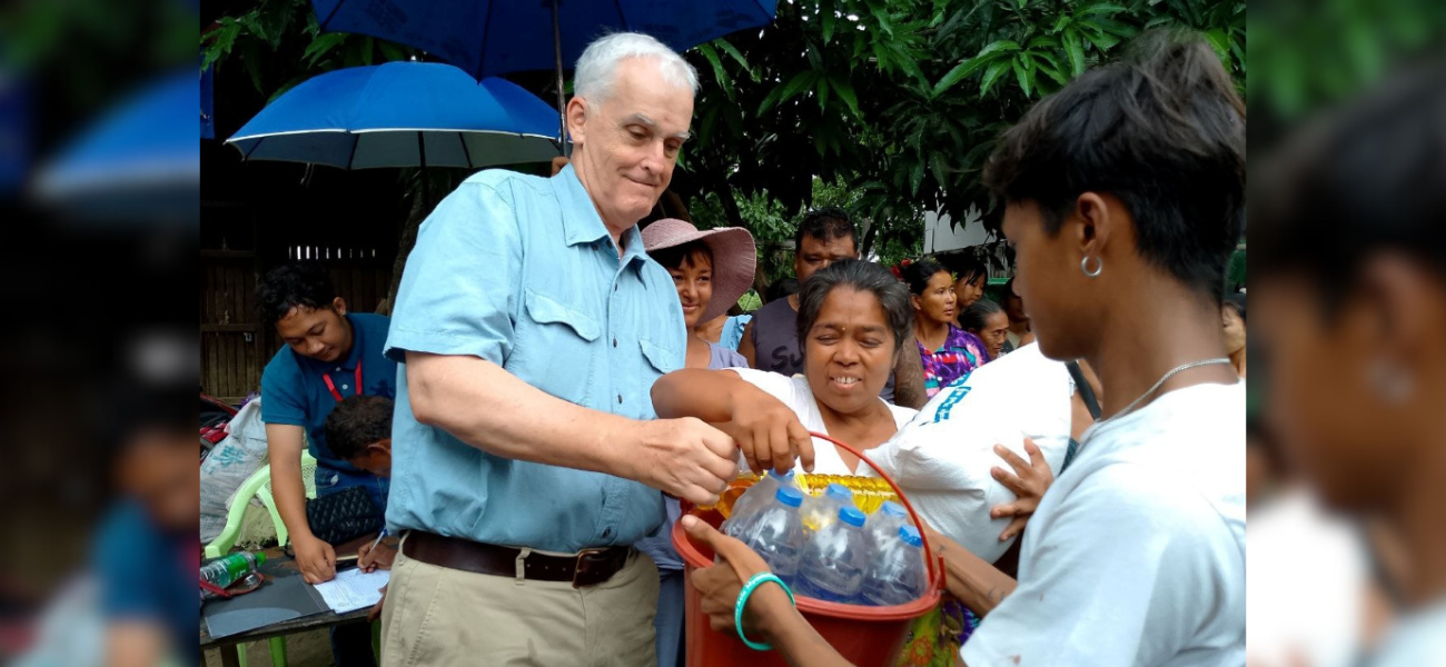 Maryknoll Father John Barth distributes food and water to survivors of an earthquake in Myanmar earlier this year. Father Barth managed funds raised by the Maryknoll Society to bring relief to survivors through the Diocese of Mandalay. (Courtesy of John Barth/Myanmar)