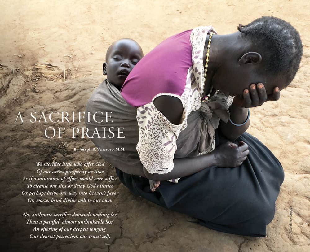 A woman sits on the ground in despair with a baby sleeping peacefully in a wrap on her back.