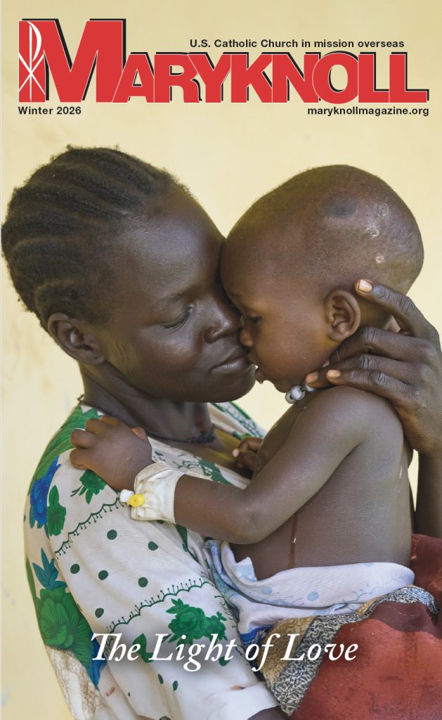 A mother holds a baby on the cover of the Winter 2026 cover of the Maryknoll Magazine