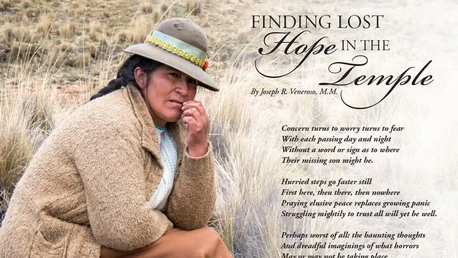 A woman sits in a dry field with a concern look on her face and her hand nervously touching her face.