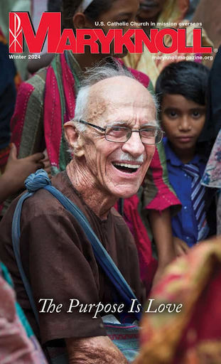The Winter 2025 Cover of Maryknoll Magazine with a picture of a Man smiling, sitting in a group of children