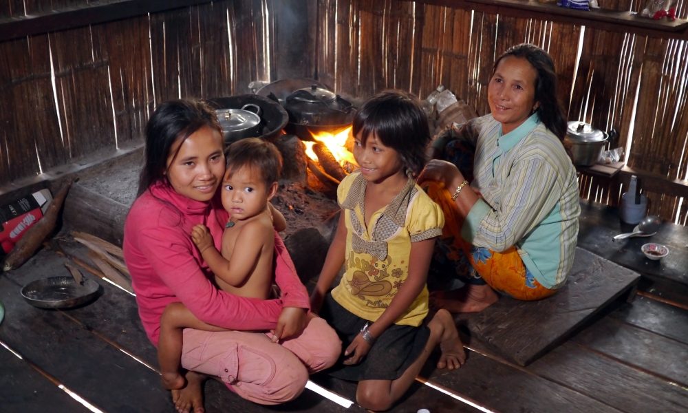An impoverished mother and her children gather around the cooking fire at their home, a shack in a settlement of Cambodia. (Sean Sprague/Cambodia)