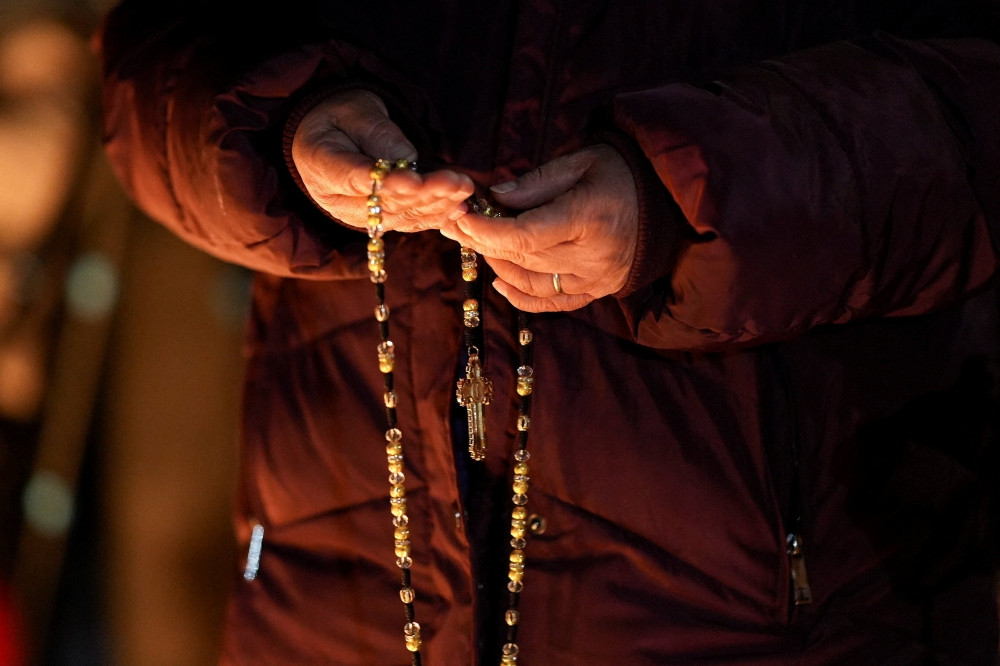 A woman holds a rosary during a vigil for a 37-year-old woman who was shot in her car by a U.S. immigration agent, according to local and federal officials, in Minneapolis Jan. 7, 2026. (OSV News/Tim Evans, Reuters)