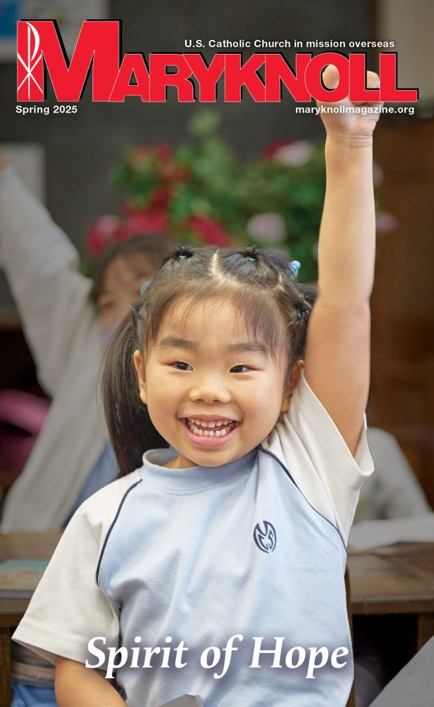 Winter 2025 cover of Maryknoll Magazine with a picture of a young girl raising her hand and smiling
