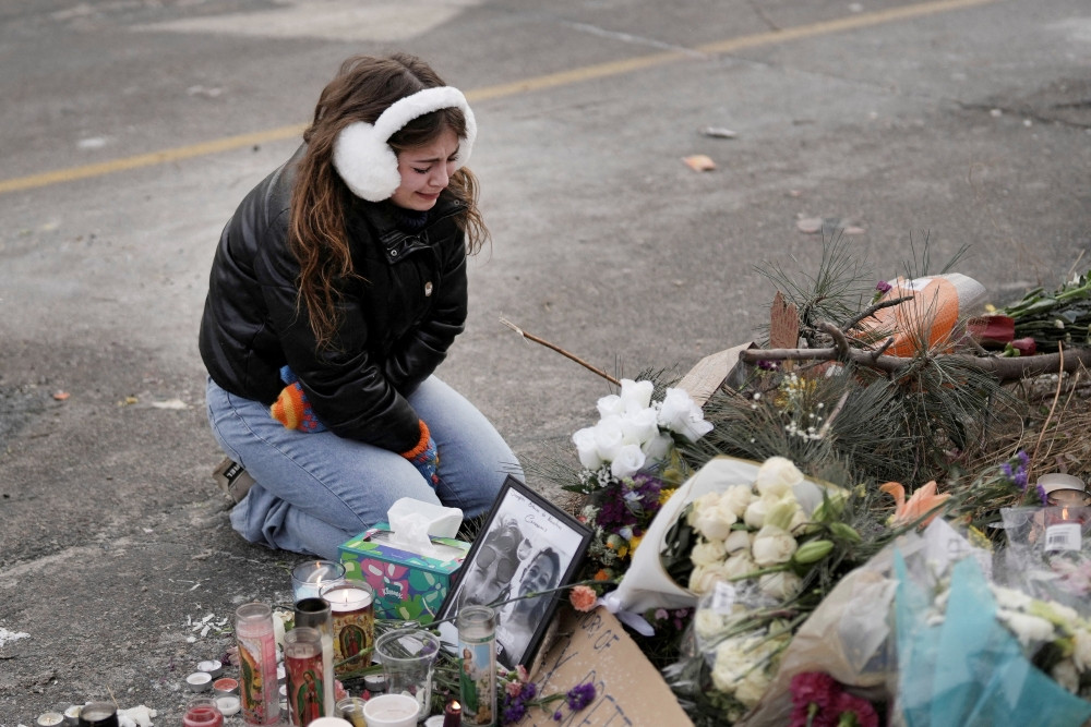 A young woman becomes emotional at a makeshift memorial in Minneapolis Jan. 25, 2026, at the site where a man was fatally shot by federal agents trying to detain him Jan. 24. Archbishop Bernard A. Hebda of St. Paul and Minneapolis, along with other Church leaders, have called for peace amid growing tensions. (OSV News/Tim Evans, Reuters)