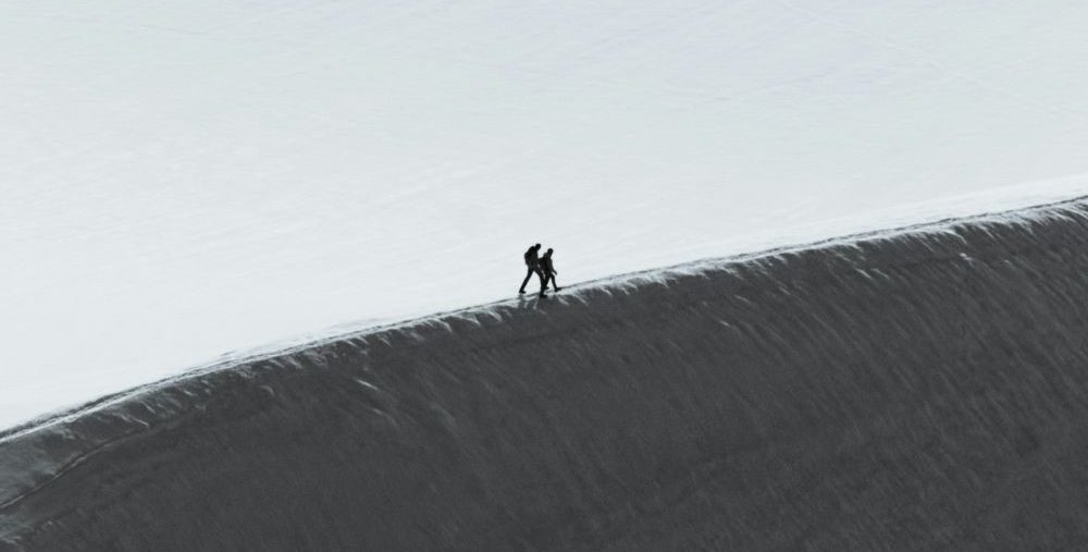 Two people climb a mountain. (Available in the public domain via Unsplash)