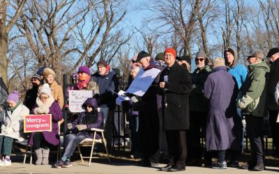Bishop Bruce Lewandowski (orange hat) of Providence, Rhode Island, leads a prayer service including a migration-themed recitation of the rosary outside the Donald Wyatt Detention Facility in his diocese. (Erik Scalavino/Rhode Island Catholic/U.S.)