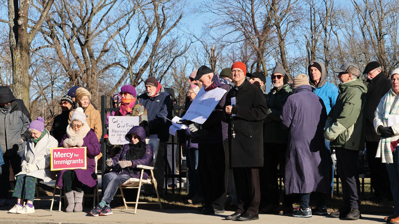 Bishop Bruce Lewandowski (orange hat) of Providence, Rhode Island, leads a prayer service including a migration-themed recitation of the rosary outside the Donald Wyatt Detention Facility in his diocese. (Erik Scalavino/Rhode Island Catholic/U.S.)