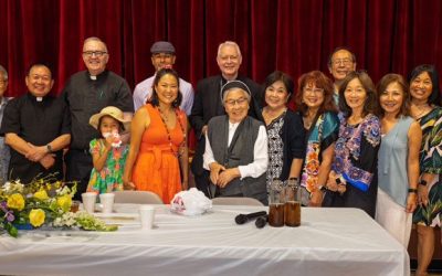 Members of Little Tokyo’s St. Francis Xavier Chapel in Los Angeles and Maryknoll Father Joseph Donovan (third from left) celebrate the blessing of “The Spirit of Our Roots” mural by Erin Yoshi (in orange dress). (Kokawa Photography/U.S.)
