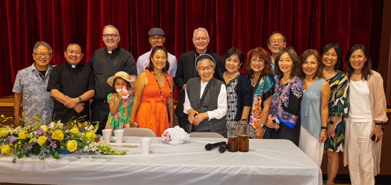Members of Little Tokyo’s St. Francis Xavier Chapel in Los Angeles and Maryknoll Father Joseph Donovan (third from left) celebrate the blessing of “The Spirit of Our Roots” mural by Erin Yoshi (in orange dress). (Kokawa Photography/U.S.)