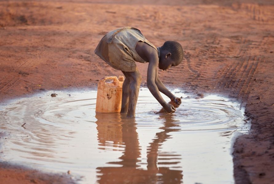 A girl fills a container with muddy water at the Ajuong Thok Refugee Camp in South Sudan, which hosts tens of thousands of displaced people from the Nuba Mountains of neighboring Sudan. (Paul Jeffrey/South Sudan)