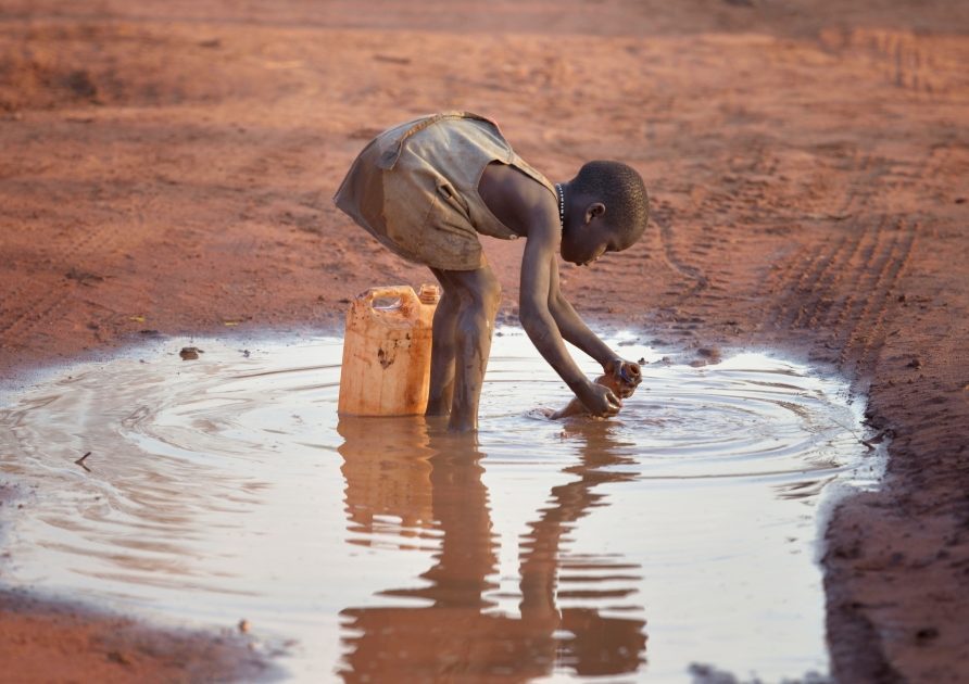 A girl fills a container with muddy water at the Ajuong Thok Refugee Camp in South Sudan, which hosts tens of thousands of displaced people from the Nuba Mountains of neighboring Sudan. (Paul Jeffrey/South Sudan)