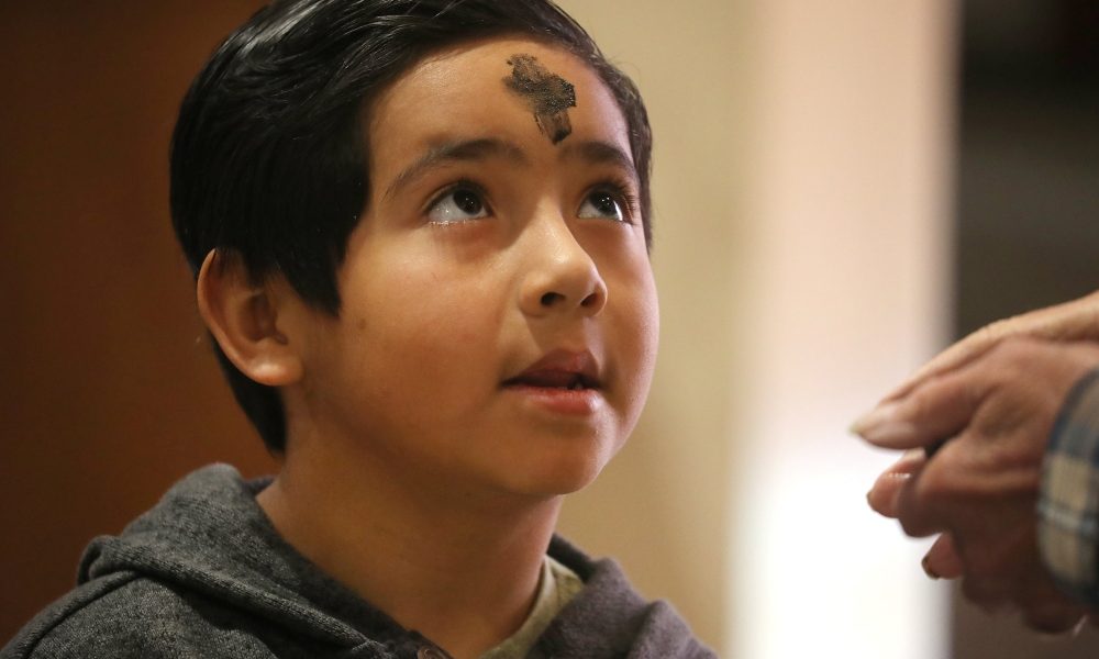 A boy looks up after receiving ashes and says, “Amen,” to the Eucharistic minister during Ash Wednesday Mass at Sacred Heart Church in Prescott, Arizona, March 5, 2025. (OSV News/Bob Roller)