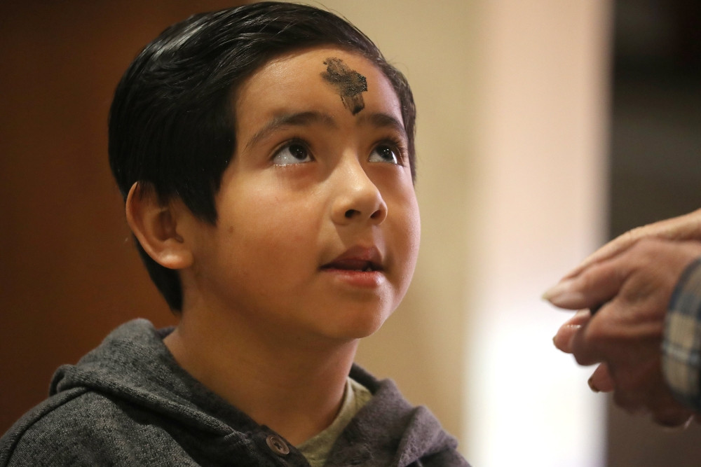 A boy looks up after receiving ashes and says, “Amen,” to the Eucharistic minister during Ash Wednesday Mass at Sacred Heart Church in Prescott, Arizona, March 5, 2025. (OSV News/Bob Roller)