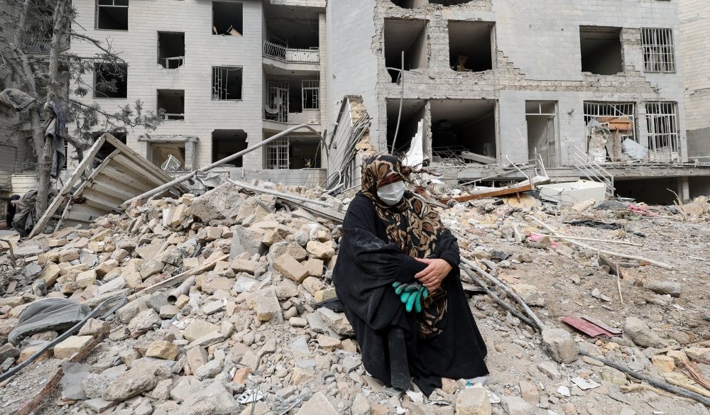 A woman sits amid rubble outside her destroyed apartment in Tehran, Iran, March 12, 2026, following an airstrike amid the U.S.-Israeli war with Iran. (OSV News/Alaa Al Marjani, Reuters)