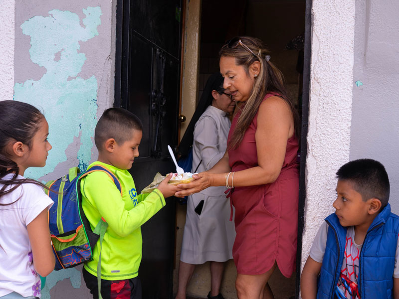 Lourdes Hernández, a trip participant, distributes food at Caminando Por La Paz, a center founded by a Maryknoll missioner. (Jeffrey Keller/Guatemala)