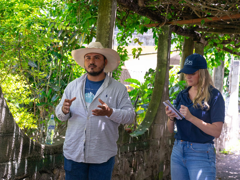Brandon explains how he received support from local CRS workers such as Jessica (right) to grow his own garden and earn income. (Jeffrey Keller/Guatemala)