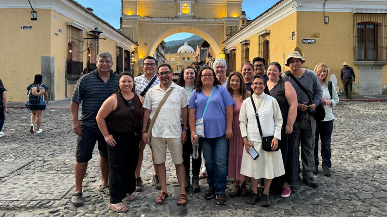 Participants in the Maryknoll Mission Formation Ministry immersion trip, including Donna Knudson (back row center, wearing white shirt and glasses), visit the Santa Catalina Arch in Antigua Guatemala. (Courtesy of Leonel Yoque/Guatemala)