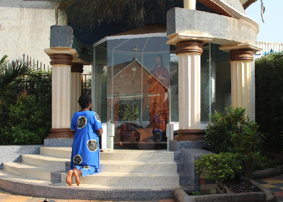 A woman kneels and prays to a statue of Jesus outside St. Paul the Apostle Catholic Church in Mukono in the central region of Uganda before going to the Catholic Martyrs’ Shrine of Namugongo June 3, 2024. (OSV News/Tonny Onyulo)