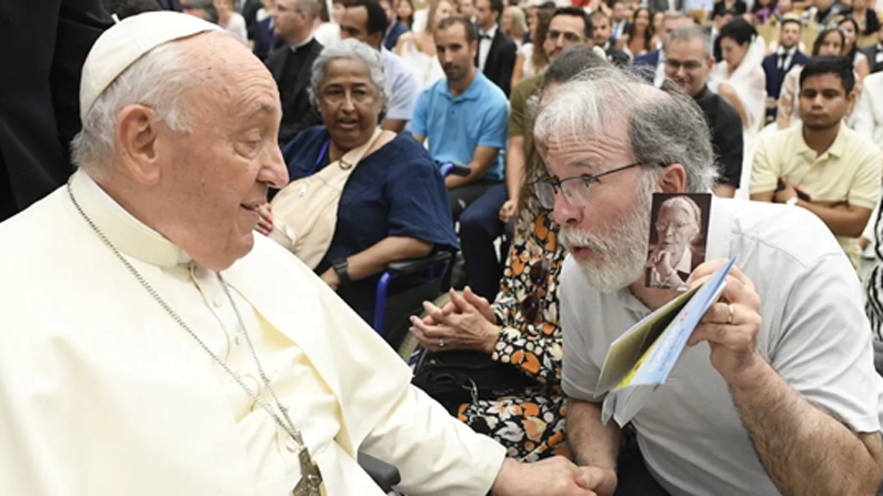 Pope Francis smiles as he recognizes a photo of Servant of God Dorothy Day depicted on a prayer card held by Robert Ellsberg, publisher of Maryknoll’s Orbis Books. (Courtesy of Robert Ellsberg/Vatican City)
