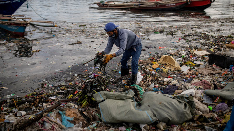 Argie Aguirre, a member of the River Warriors, gathers trash from the polluted Pasig River in Manila, Philippines, June 22, 2021. Pope Francis released his landmark environmental encyclical “Laudato Si'” 10 years ago May 14, 2015. (OSV News/Eloisa Lopez, Reuters)