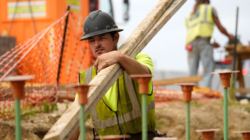 A worker carries lumber at a highway construction site in Stony Brook, New York, Aug. 30, 2022. (OSV News/CNS file, Gregory A. Shemitz)