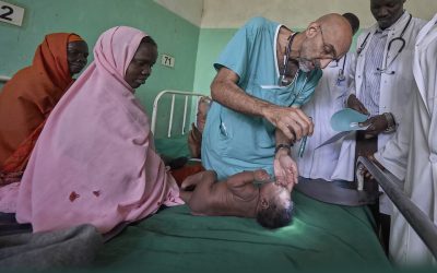 Dr. Tom Catena, a Catholic lay missionary from the United States, examines a baby during rounds in late April at the Mother of Mercy Hospital in Gidel, a village in the Nuba Mountains of Sudan. The Catholic hospital, at which Catena is often the only physician, is the only referral hospital in the war-torn area. (CNS/Paul Jeffrey/Sudan)