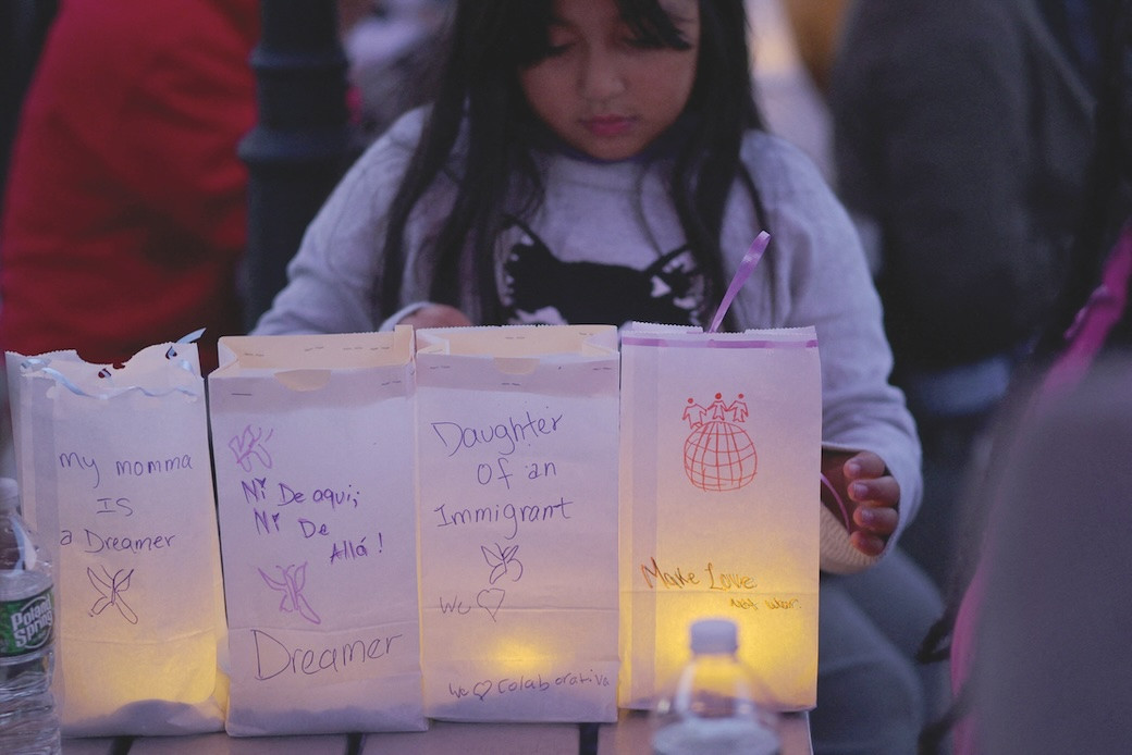 An 8-year-old girl arranges luminaries with messages about her mother, a DACA “dreamer,” during a vigil in Chelsea, Massachusetts, a community affected by raids and detentions by Immigration and Customs Enforcement. (OSV News/Brian Snyder/Reuters/U.S.)