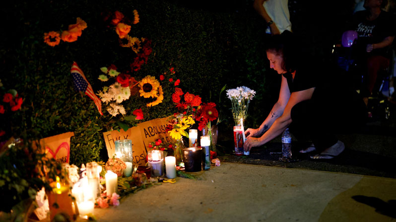 A woman places a candle at a makeshift memorial at Mechanics Park in Biddeford, Maine, July 13, 2026, after a U.S. Immigration and Customs Enforcement agent fatally shot a motorist. The Department of Homeland Security in a statement said that “fearing for public safety,” the officer opened fire after the driver allegedly tried to use his vehicle as a weapon against ICE agents. (OSV News/CJ Gunther, Reuters)