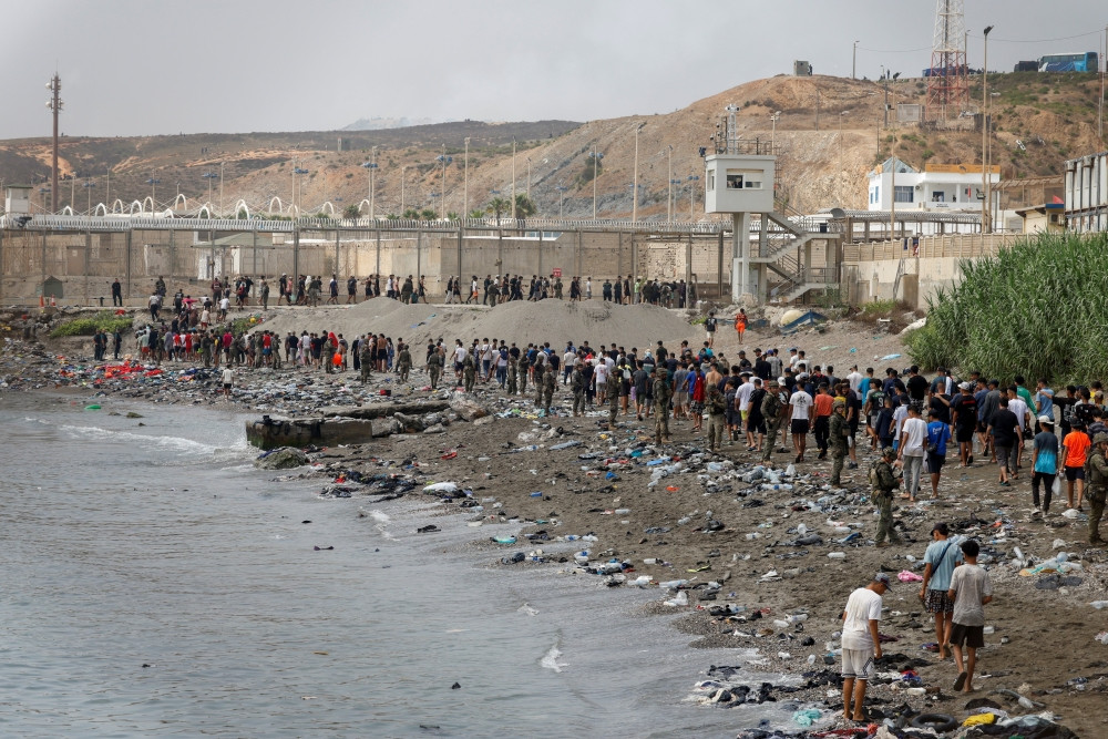 People in Ceuta, Spain, walk toward the border with Morocco as they leave Spanish territory on July 31, 2026, amid massive crossings of migrants — on foot and by sea — from Morocco into Spanish territory. The Diocese of Cádiz and Ceuta provided emergency resources to civil authorities on July 31, when more than 60,000 migrants crossed from Morocco into the Spanish enclave of Ceuta, overwhelming local infrastructure. (OSV News/Jon Nazca, Reuters)